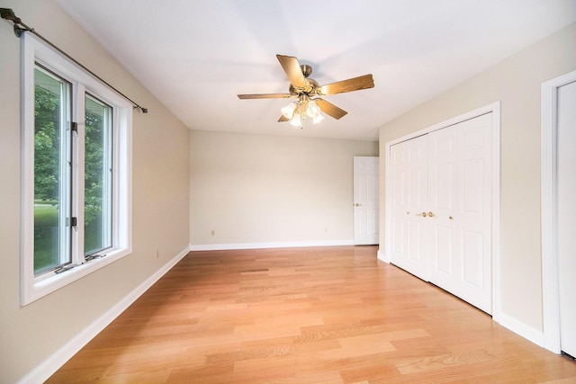 6990 Kennedy Rd, Munith, MI 49259 - unfurnished bedroom with light wood-style flooring, a closet, and ceiling fan