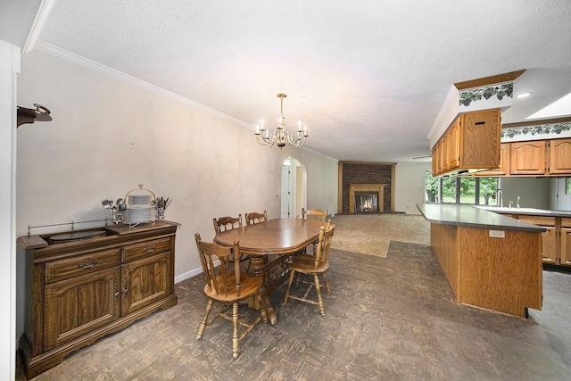 6990 Kennedy Rd, Munith, MI 49259 - dining area with crown molding, arched walkways, a chandelier, a textured ceiling, and a lit fireplace