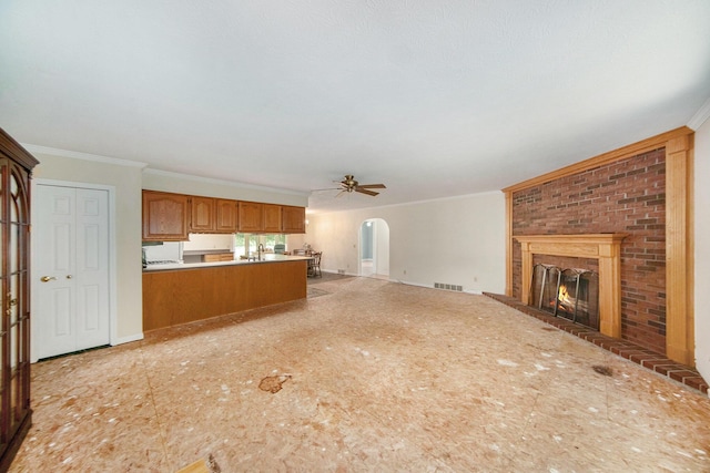 6990 Kennedy Rd, Munith, MI 49259 - unfurnished living room with ceiling fan, a fireplace, arched walkways, and ornamental molding