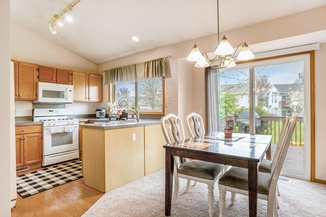 5767 E Grove Dr SE, Kentwood, MI 49512 - kitchen featuring white appliances, a chandelier, lofted ceiling, decorative light fixtures, and light wood-style flooring