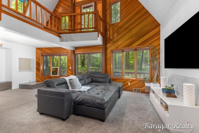9550 Pere Marquette Dr, Stanwood, MI 49346 - living room featuring high vaulted ceiling, wood walls, plenty of natural light, and carpet floors