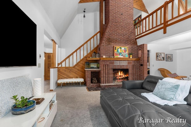9550 Pere Marquette Dr, Stanwood, MI 49346 - living room with high vaulted ceiling, stairway, carpet flooring, and a fireplace