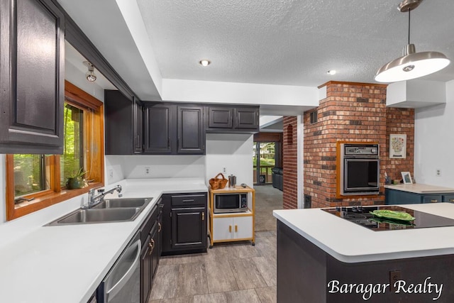 9550 Pere Marquette Dr, Stanwood, MI 49346 - kitchen with black appliances, a textured ceiling, light countertops, hanging light fixtures, and a center island