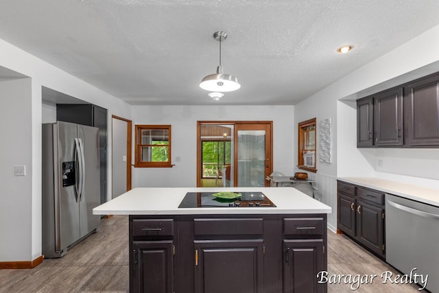 9550 Pere Marquette Dr, Stanwood, MI 49346 - kitchen with stainless steel appliances, light countertops, a center island, pendant lighting, and light wood-type flooring