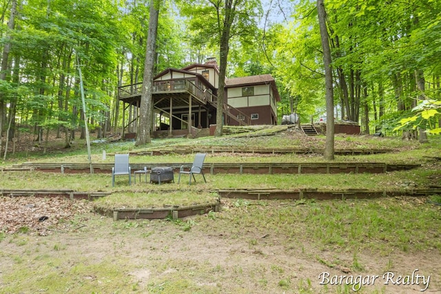 9550 Pere Marquette Dr, Stanwood, MI 49346 - rear view of property with a fire pit, a deck, stairs, and a chimney