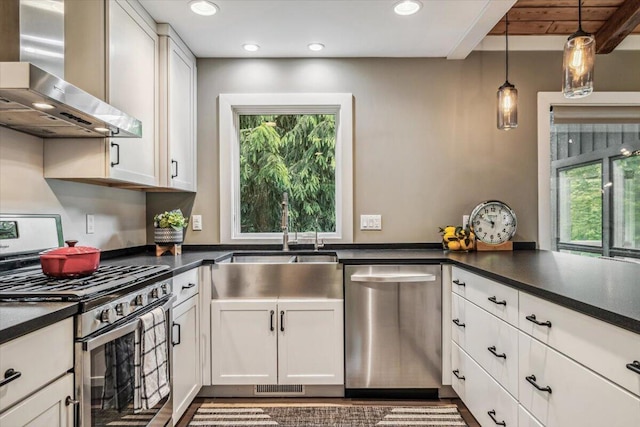 16128 Walnut Ct, Three Oaks, MI 49128 - kitchen featuring appliances with stainless steel finishes, wall chimney exhaust hood, dark countertops, plenty of natural light, and recessed lighting