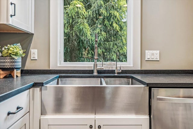 16128 Walnut Ct, Three Oaks, MI 49128 - kitchen featuring stainless steel dishwasher, dark countertops, and white cabinetry