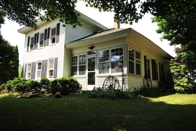 14585 E V Ave, Fulton, MI 49052 - view of property exterior featuring a lawn, a chimney, and a sunroom