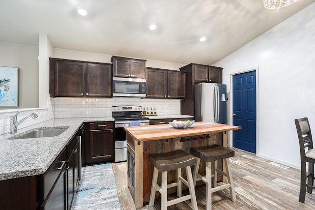 25220 Forest Ln, Mattawan, MI 49071 - kitchen with appliances with stainless steel finishes, dark brown cabinets, backsplash, lofted ceiling, and wooden counters