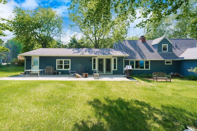 2821 Lakeshore Rd, Lexington, MI 48450 - back of property featuring a patio, a lawn, a chimney, and roof with shingles