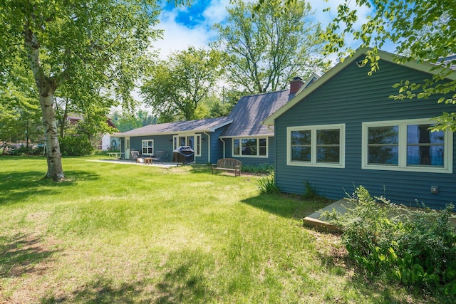 2821 Lakeshore Rd, Lexington, MI 48450 - back of property with a chimney, a lawn, and a patio