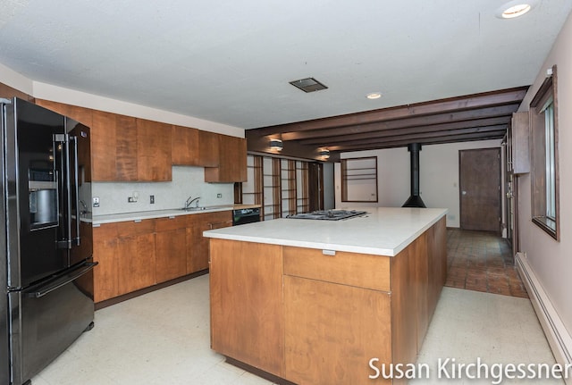 1129 Idema Dr SE, Grand Rapids, MI 49506 - kitchen with black appliances, a baseboard radiator, a center island, brown cabinets, and light countertops