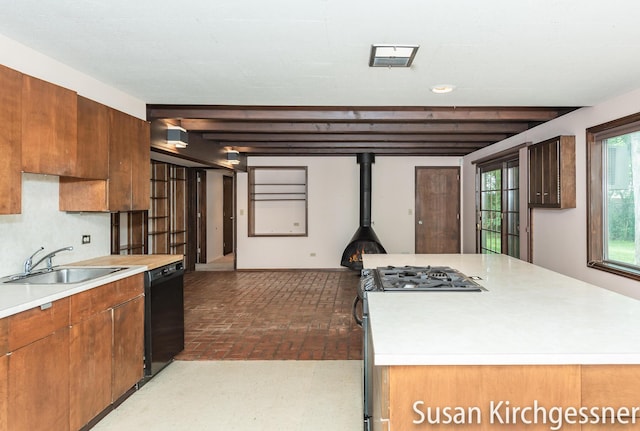 1129 Idema Dr SE, Grand Rapids, MI 49506 - kitchen featuring dishwasher, brick flooring, light countertops, gas range, and a kitchen island