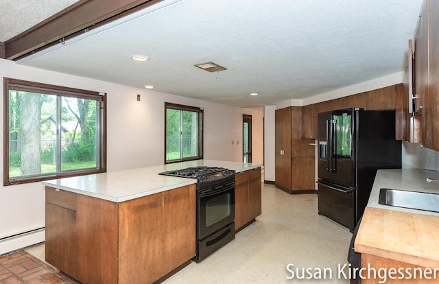 1129 Idema Dr SE, Grand Rapids, MI 49506 - kitchen featuring black appliances, light countertops, a baseboard radiator, a center island, and recessed lighting