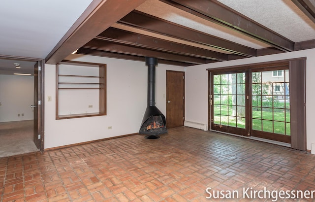 1129 Idema Dr SE, Grand Rapids, MI 49506 - unfurnished living room with a baseboard heating unit, brick floors, a wood stove, and beam ceiling