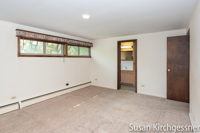 1129 Idema Dr SE, Grand Rapids, MI 49506 - unfurnished bedroom with a baseboard radiator, carpet, and connected bathroom
