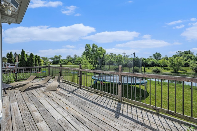 1735 Savannah Ln, Ypsilanti, MI 48198 - deck featuring a trampoline, a yard, and view of wooded area