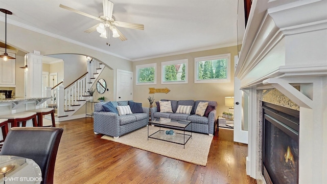 120 S Kenzie St, New Buffalo, MI 49117 - living room featuring a glass covered fireplace, a ceiling fan, stairway, wood finished floors, and crown molding