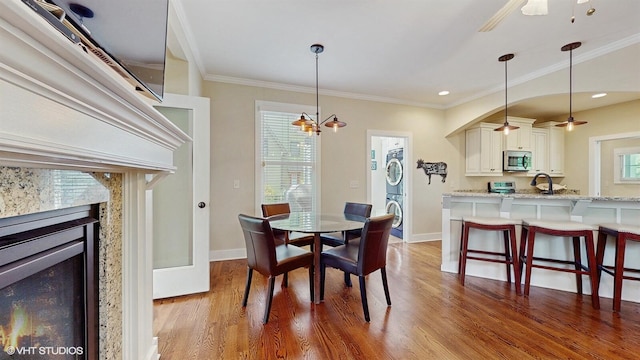 120 S Kenzie St, New Buffalo, MI 49117 - dining space with a ceiling fan, wood finished floors, crown molding, and a high end fireplace