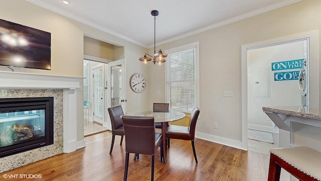 120 S Kenzie St, New Buffalo, MI 49117 - dining room featuring wood finished floors, ornamental molding, and a multi sided fireplace