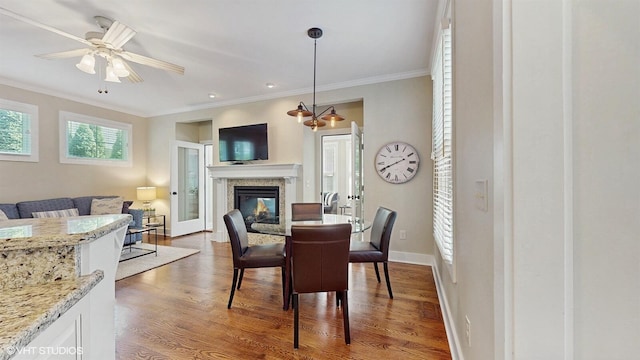 120 S Kenzie St, New Buffalo, MI 49117 - dining area with ornamental molding, wood finished floors, a glass covered fireplace, and a ceiling fan