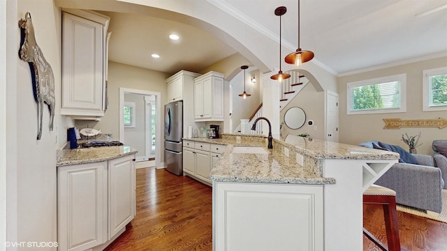 120 S Kenzie St, New Buffalo, MI 49117 - kitchen with arched walkways, a peninsula, freestanding refrigerator, open floor plan, and ornamental molding