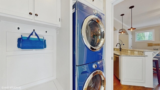 120 S Kenzie St, New Buffalo, MI 49117 - laundry room with stacked washer / dryer, ornamental molding, wood finished floors, and bar with sink