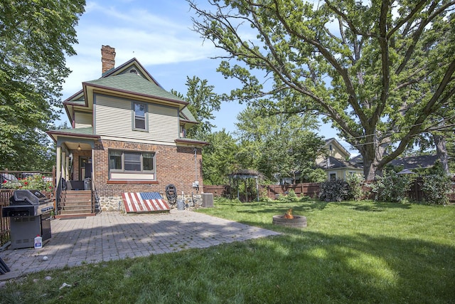 73640 Fulton St, Armada, MI 48005 - rear view of property with an outdoor fire pit, a chimney, a fenced backyard, brick siding, and a patio area