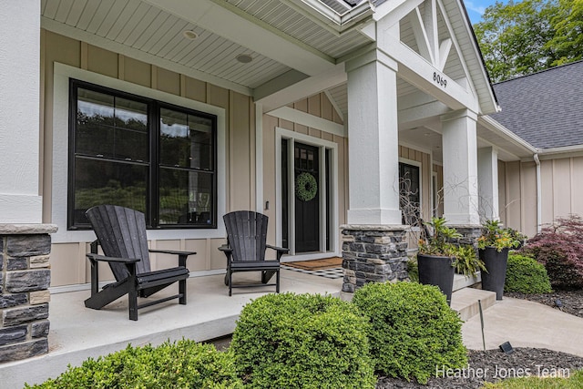 8069 Ella Terrace Ct, Rockford, MI 49341 - property entrance featuring board and batten siding, covered porch, stone siding, and roof with shingles