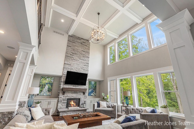 8069 Ella Terrace Ct, Rockford, MI 49341 - living room featuring a towering ceiling, a stone fireplace, coffered ceiling, beam ceiling, and decorative columns