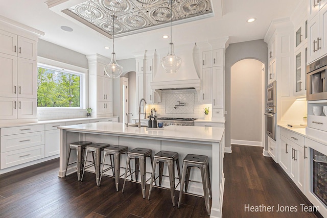 8069 Ella Terrace Ct, Rockford, MI 49341 - kitchen featuring arched walkways, a raised ceiling, stainless steel appliances, and recessed lighting