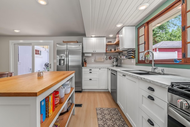 65 Salem St, Hillsdale, MI 49242 - kitchen featuring stainless steel appliances, open shelves, butcher block counters, recessed lighting, and white cabinetry