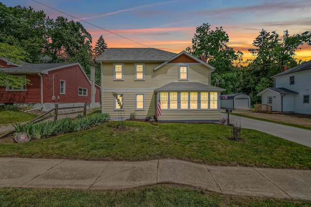 65 Salem St, Hillsdale, MI 49242 - traditional-style home featuring an outdoor structure, driveway, a detached garage, a lawn, and a shingled roof