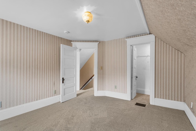 1218 Forest Ave, Jackson, MI 49201 - unfurnished bedroom featuring wallpapered walls, carpet, a closet, and lofted ceiling