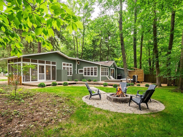 6670 Ravenswood Ave, Sawyer, MI 49125 - back of house featuring a fire pit, a sunroom, and a lawn