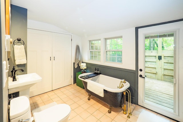 6670 Ravenswood Ave, Sawyer, MI 49125 - full bath featuring vaulted ceiling, a soaking tub, a wainscoted wall, and tile patterned floors