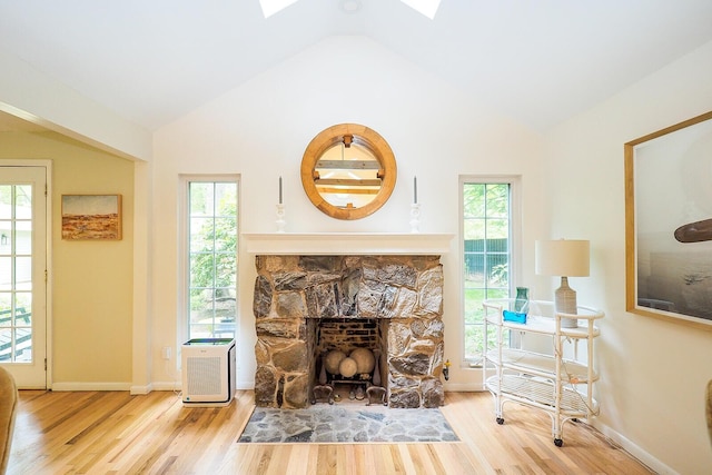 6670 Ravenswood Ave, Sawyer, MI 49125 - living area featuring wood finished floors, vaulted ceiling, a fireplace, and a skylight