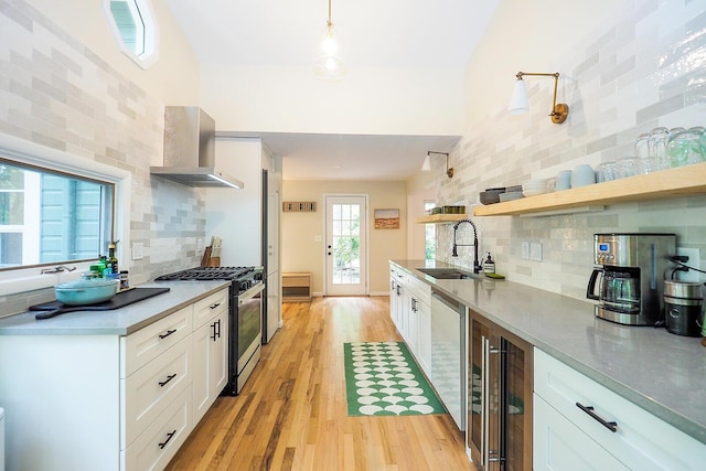 6670 Ravenswood Ave, Sawyer, MI 49125 - kitchen with stainless steel gas range oven, wall chimney exhaust hood, beverage cooler, light wood-style floors, and tasteful backsplash