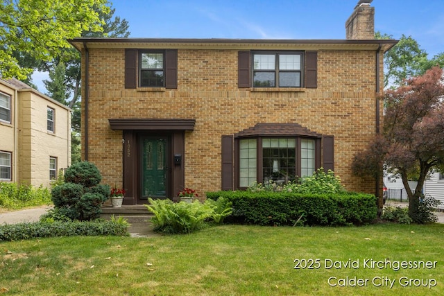 1052 Santa Cruz Dr SE, Grand Rapids, MI 49506 - view of front facade featuring a chimney, a front yard, and brick siding