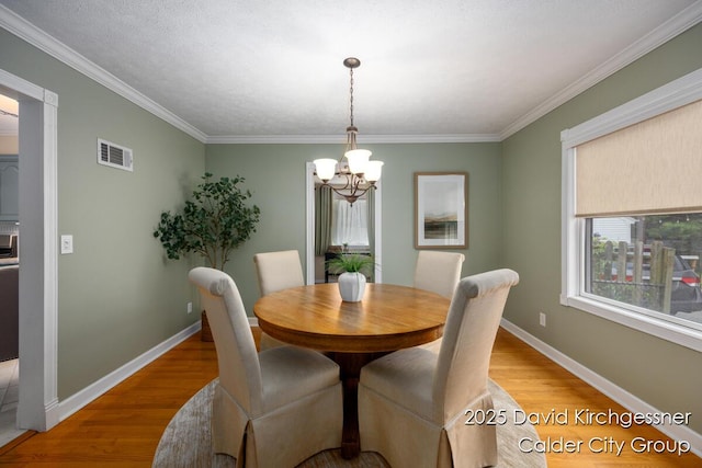 1052 Santa Cruz Dr SE, Grand Rapids, MI 49506 - dining area with a chandelier, light wood-type flooring, and crown molding