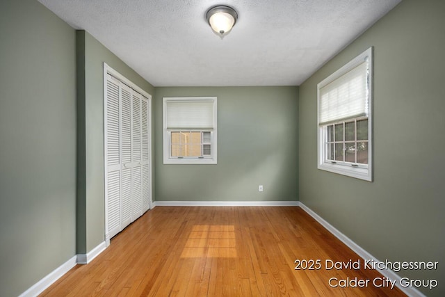 1052 Santa Cruz Dr SE, Grand Rapids, MI 49506 - unfurnished bedroom featuring a closet, light wood-style flooring, and a textured ceiling