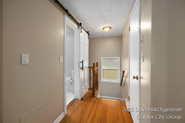 1052 Santa Cruz Dr SE, Grand Rapids, MI 49506 - corridor with a barn door, an upstairs landing, and light wood-style floors