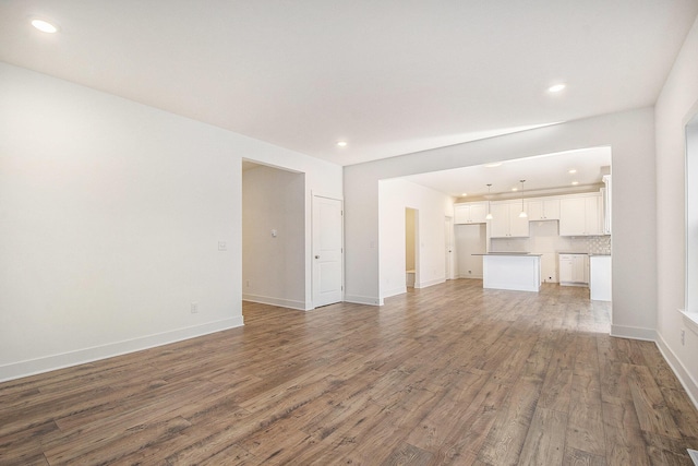 12379 Jenks St NE, Belding, MI 48809 - unfurnished living room featuring wood finished floors and recessed lighting