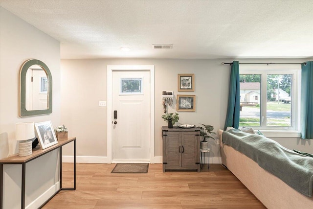 211 W S St, Grand Ledge, MI 48837 - entryway featuring light wood-type flooring and a textured ceiling