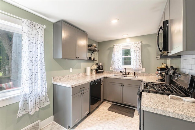 211 W S St, Grand Ledge, MI 48837 - kitchen featuring black appliances, gray cabinetry, open shelves, light countertops, and backsplash