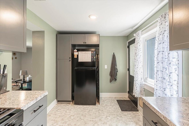 211 W S St, Grand Ledge, MI 48837 - kitchen with freestanding refrigerator, gray cabinetry, light countertops, and electric stove