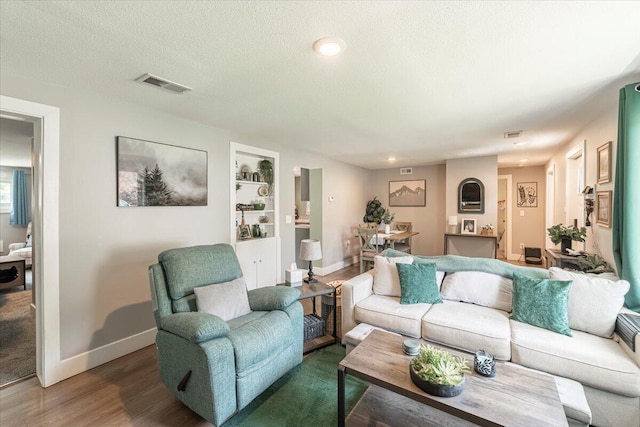 211 W S St, Grand Ledge, MI 48837 - living area featuring wood finished floors, built in shelves, a textured ceiling, and recessed lighting