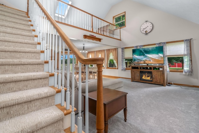 31688 Colon Rd, Colon, MI 49040 - stairway featuring high vaulted ceiling, a chandelier, plenty of natural light, carpet flooring, and a glass covered fireplace
