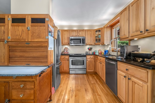 31688 Colon Rd, Colon, MI 49040 - kitchen featuring stainless steel appliances, light wood finished floors, glass insert cabinets, and dark countertops