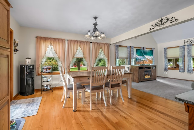 31688 Colon Rd, Colon, MI 49040 - dining space featuring a chandelier, plenty of natural light, light wood-type flooring, lofted ceiling, and a glass covered fireplace